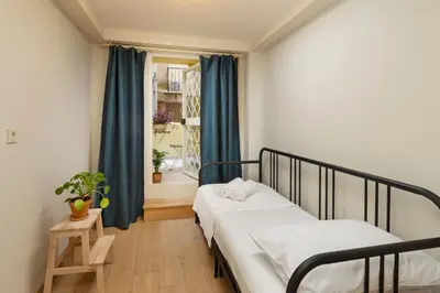 a bedroom with two beds and a window with blue curtains at Havyar Apartment in Istanbul
