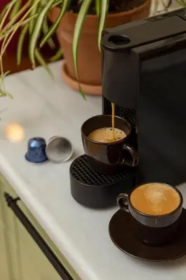 two cups of coffee on a counter next to a coffee maker at Havyar Apartment in Istanbul