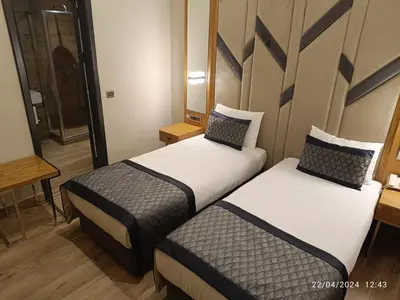 a hotel room with two beds and a mirror at Sultanahmet Newport Hotel in Istanbul