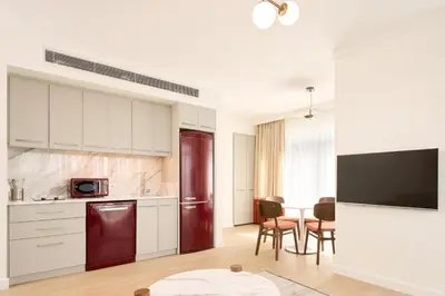 a kitchen with white cabinets and a table with chairs at The Marmara Camlica in Istanbul