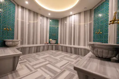a bathroom with green tile and a tub and a sink at New Inn Hotel Old Town in Istanbul