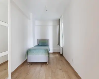 a small bedroom with a bed in a white room at Allegro Apartments Kadıköy in Istanbul