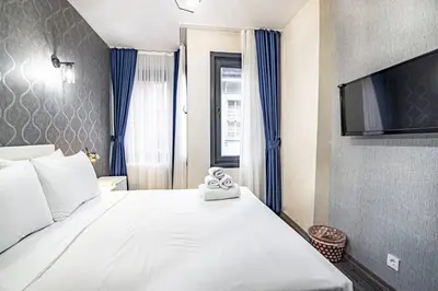 a bedroom with a large white bed with a flat screen tv at Deluxe Double Room 4 in Istanbul