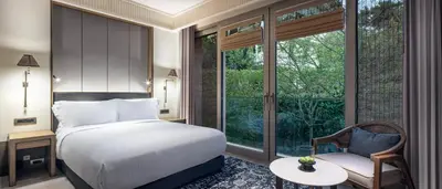 a bedroom with a bed and a chair and a window at Princes' Palace Resort, Buyukada - Member of The Leading Hotels of the World in Adalar