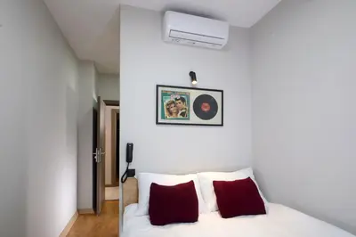 a bedroom with a white bed with red pillows at Meet İstanbul Hotel Kadikoy in Istanbul