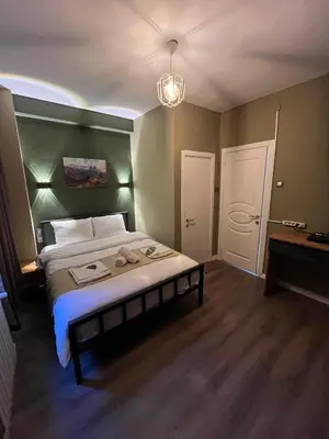 a bedroom with a bed with a green headboard at THE BEYBÛN HOTEL İstiklal Street Taksim in Istanbul