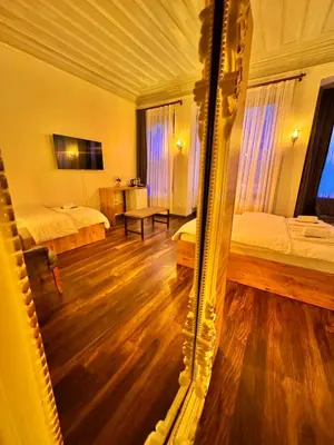 a reflection of a bedroom with two beds and a mirror at Otel Kadıköy in Istanbul