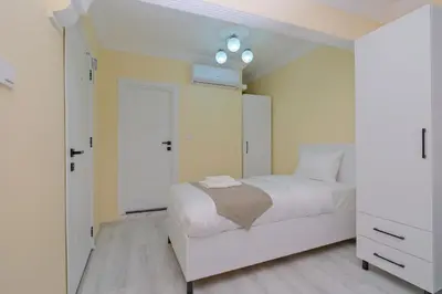 a bedroom with a white bed and a white closet at Lucky Hotel İstanbul in Istanbul