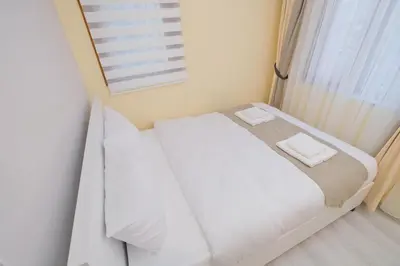 a white bed in a room with a window at Lucky Hotel İstanbul in Istanbul