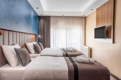 a hotel room with two beds and a flat screen tv at Marlon Hotel in Istanbul