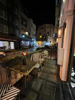 a table and chairs on a balcony at night at Marlon Hotel in Istanbul