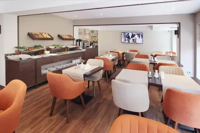 a restaurant with white tables and orange chairs at Pisa Hotel in Istanbul