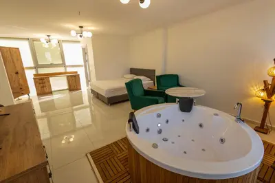 a bathroom with a bath tub and a bedroom at Karamürsel Mohti Otel Fitness Organizasyon in Karamusal