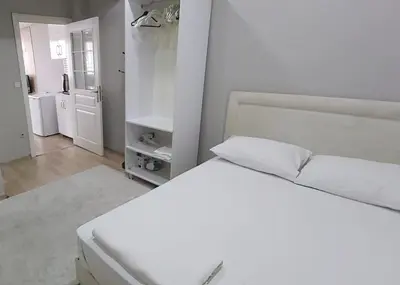 a white bedroom with two beds and a bathroom at Hane Apart in Istanbul