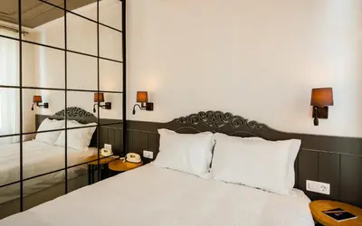 a bedroom with a large white bed and a mirror at Pino Verde Hotel in Istanbul
