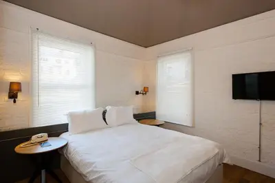 a bedroom with a white bed and a flat screen tv at Pino Verde Hotel in Istanbul