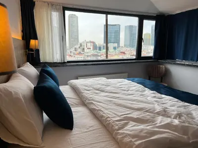 a bed in a bedroom with a view of a city at The Blue Suites in Istanbul