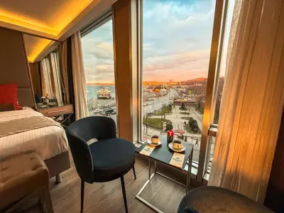 a room with a bed and a table and a window at Manesol Old City Bosphorus in Istanbul