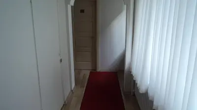 a hallway with a red rug next to a door at Kadikoy Bade 3 Hotel in Istanbul
