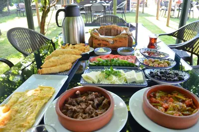 a table filled with different types of food on plates at Serbesler Botanik, No 1 Comfortable Villa in Sakarya