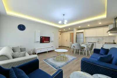 a living room with blue couches and a kitchen at Kardeş Suite 5 in Istanbul