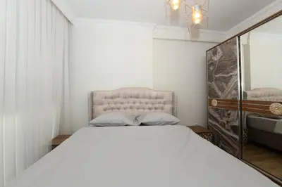 a bedroom with a white bed and a mirror at Kardeş Suite 5 in Istanbul