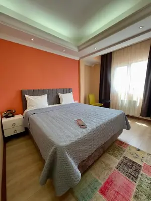 a bedroom with a large bed with an orange wall at Elite Marmara Express Otel in Istanbul