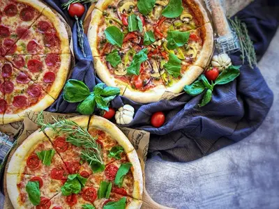 three pizzas sitting on top of a table at Elysian Airport Hotel & Restaurant in Arnavutköy