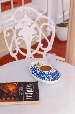 a book and a cup of coffee on a table at Aşiyan Yalısı in İznik