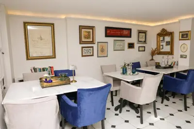 a dining room with two tables and blue chairs at Aşiyan Yalısı in İznik