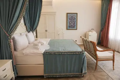 a bedroom with a bed with green curtains and a chair at Aşiyan Yalısı in İznik