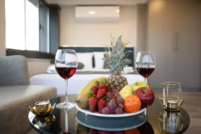 a plate of fruit on a table with two glasses of wine at Swans Hotel Old City Grand Bazar in Istanbul