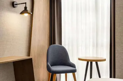 a blue chair sitting next to a window at Ramada Encore by Wyndham Istanbul Arnavutkoy in Istanbul