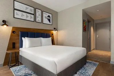 a hotel room with a large bed and a door at Ramada Encore by Wyndham Istanbul Arnavutkoy in Istanbul