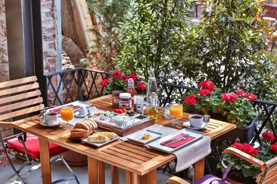 a wooden table with breakfast food on a patio at Hammamhane Hotel in Istanbul