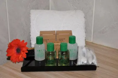 a shelf with four bottles of soap and a red flower at KAT11 in Beylikduzu