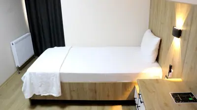 a small bedroom with a bed and a table at Vizyon Otel Darıca in Darıca