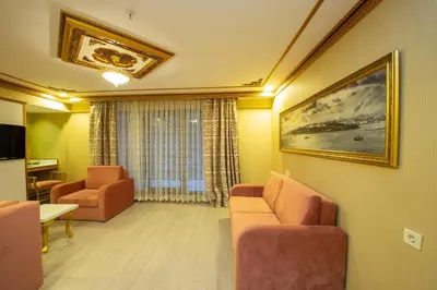 a living room with two chairs and a painting on the wall at Empire Suite Hotel in Istanbul