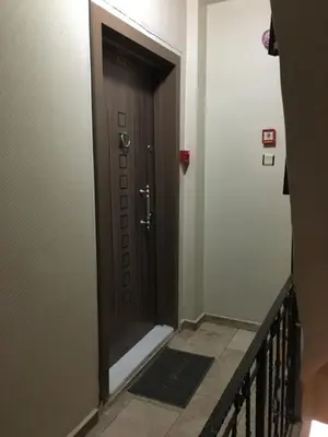 a brown door in a hallway with a staircase at Konak Apart Hotel in Istanbul