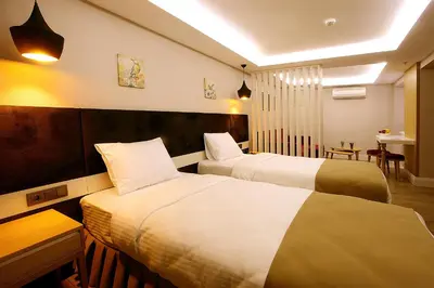 a hotel room with two beds and a table at Carina Park Suites Nisantasi in Istanbul