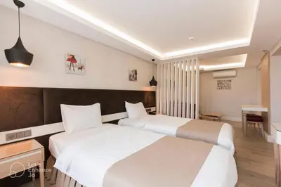 a hotel room with two beds and a desk at Carina Park Suites Nisantasi in Istanbul