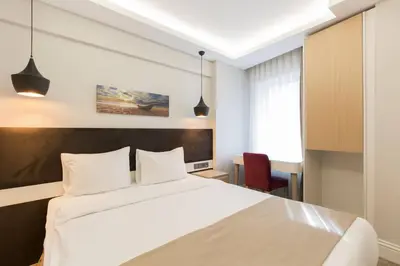 a bedroom with a white bed and a desk at Carina Park Suites Nisantasi in Istanbul