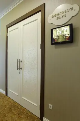 a door in a room with a sign on the wall at Luxor Garden Hotel in Kocaeli