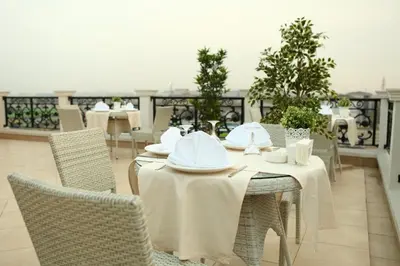 a table with white tables and chairs on a balcony at Luxor Garden Hotel in Kocaeli