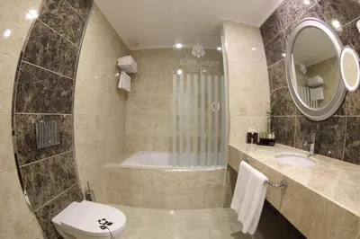 a bathroom with a tub and a toilet and a sink at Luxor Garden Hotel in Kocaeli