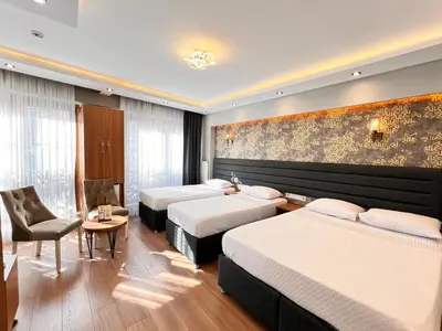 a hotel room with two beds and a chair at Mamma Marya Hotel in Istanbul