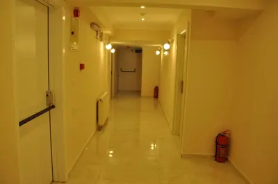 a hallway with a long corridor with white walls at Hotel Iscen in Mustafakemalpaşa