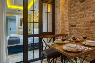 a wooden table with two chairs and glasses of wine at Mahhsen Mansion Oldcity in Istanbul