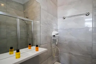 a bathroom with a shower with a hair dryer on the wall at Californiacityhotel in Istanbul