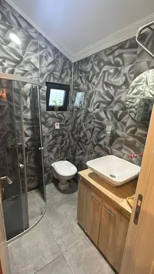 a bathroom with a toilet and a tv on the wall at BungalovCity in Sapanca